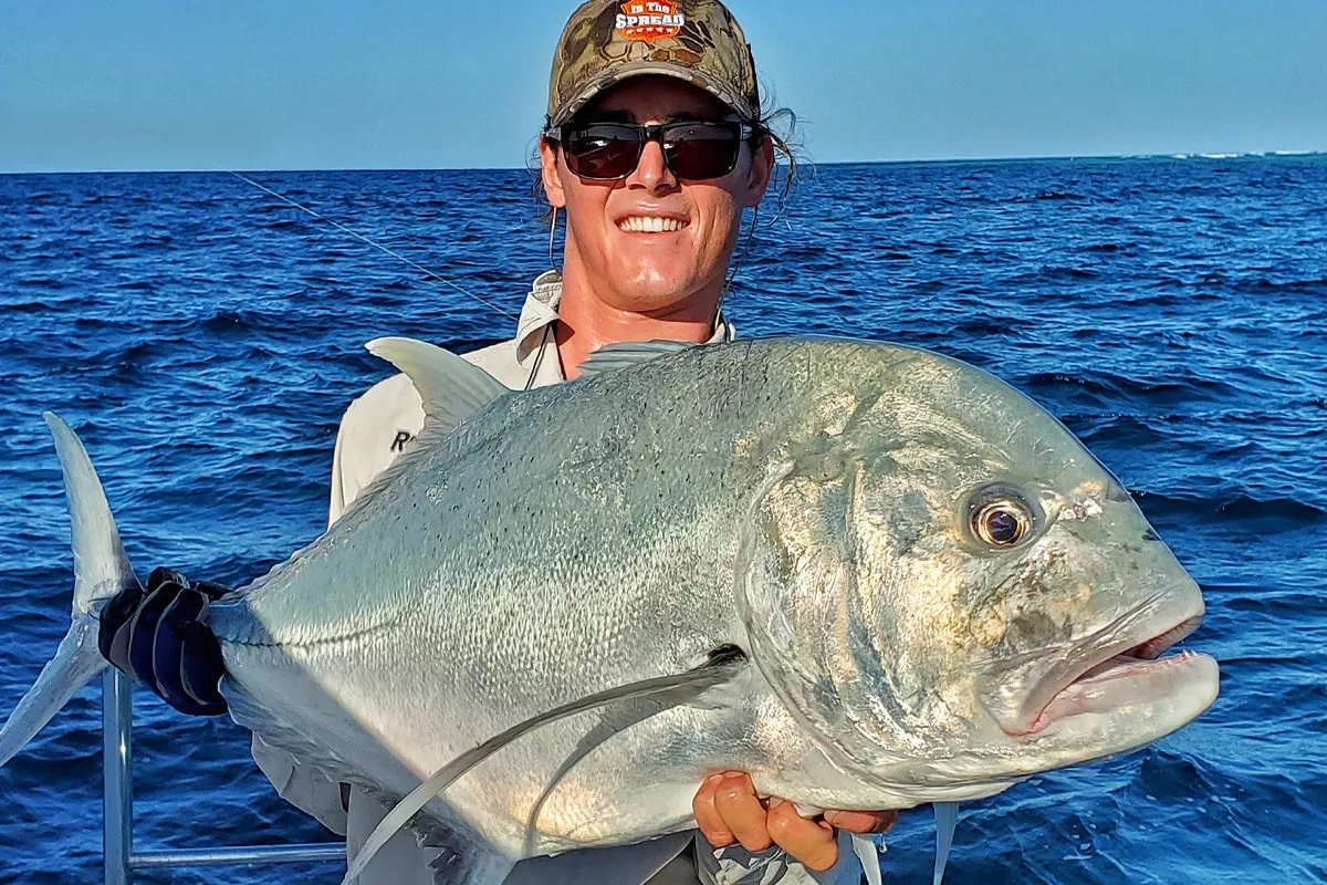 Chris Rushford shows off his catch after Reef Fishing for Giant Trevally