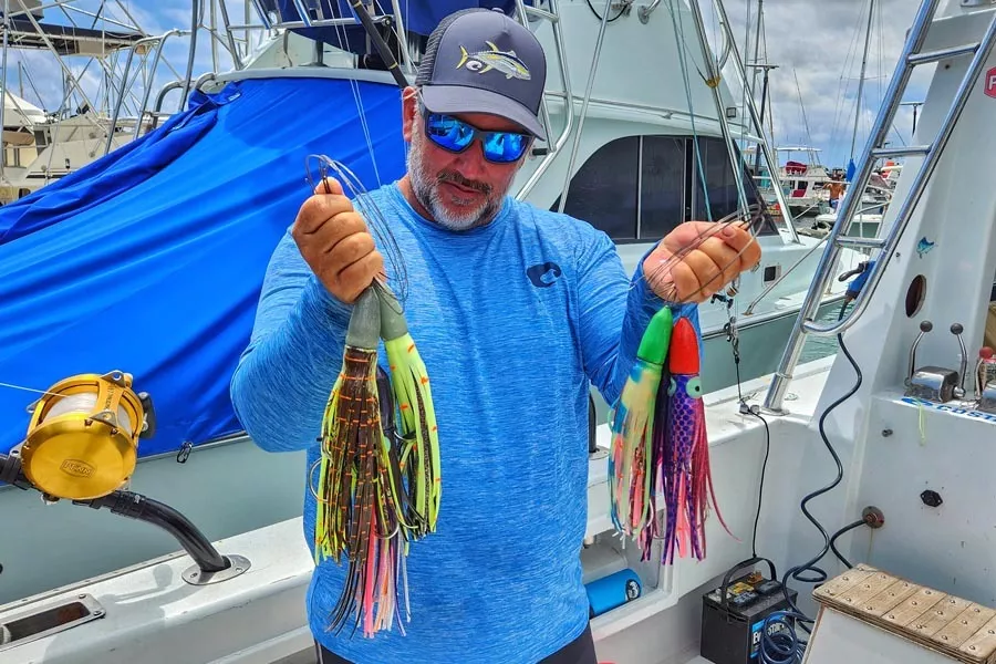 shawn rotella holding a collection of his custom bullet lures for wahoo