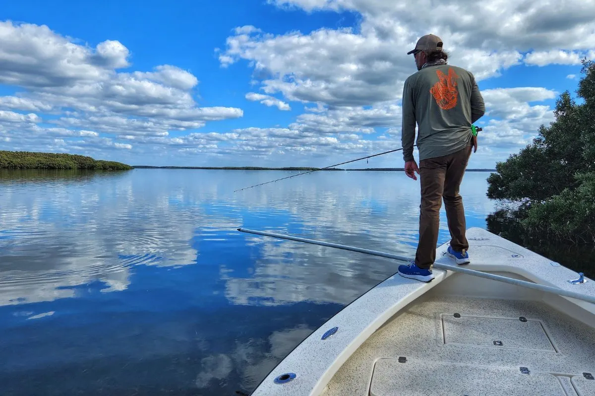 Boat-level view of angler sight casting a shallow Florida seagrass flat