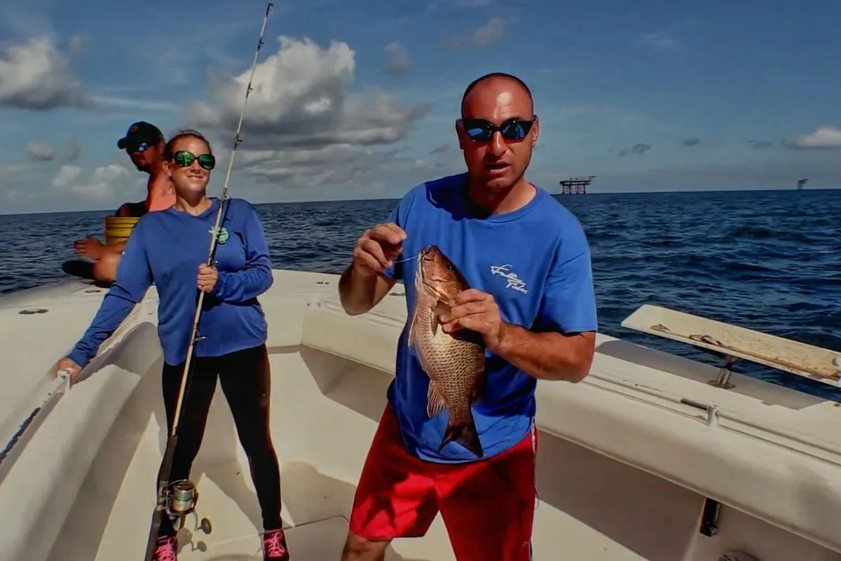 Capt. Josh Howard holding a nice mangrove snapper caught fishing oil platforms in Louisiana