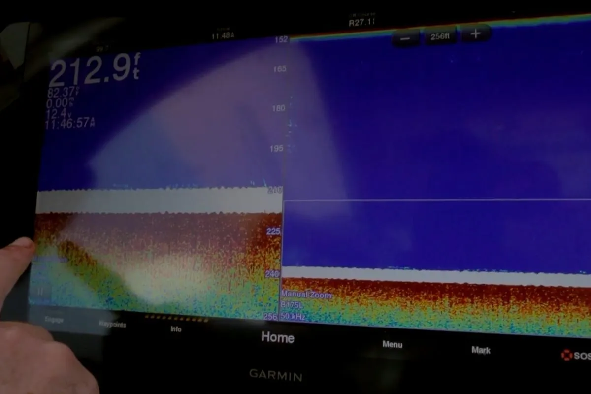 Kevin Adney pointing to hard bottom structure on a Garmin fishfinder while targeting red snapper