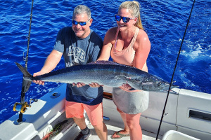 Shawn Rotella holding a wahoo caught slow trolling live bait in Hawaii
