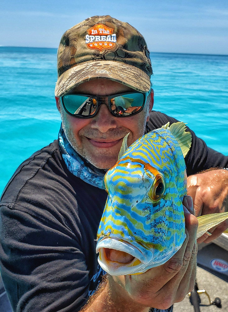 In The Spread founder Seth Horne holding a sailfin snapper at Rowley Shoals in the Indian Ocean