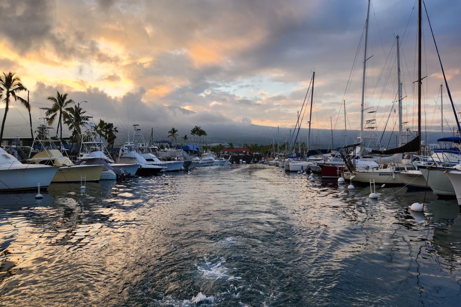 Sportfishing charter boat leaving the Honokohau marina in Kona Hawaii at sunrise for a guided fishing trip. 