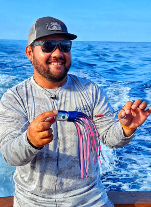 Kris Ishibashi holding a blue marlin lure rigged with Sta-Stuk hook