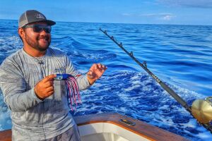 Kris Ishibashi holding a blue marlin lure rigged with Sta-Stuk hook