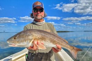 William Toney stands in his skiff with a 31 inch winter redfish caught sight casting on Homosassa flats