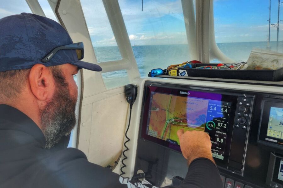 Captain Vlad Moldoveanu marking a spot on his Simrad chart plotter while reading reef structure off Alabama