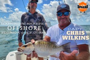Chris Wilkins with a mangrove snapper caught on Gulf hard bottom off Homosassa as Capt. William Toney looks on