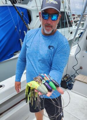 Seth Horne holding a big wahoo caught in Costa Rica with an All or Nothing stickbait hanging from its mouth